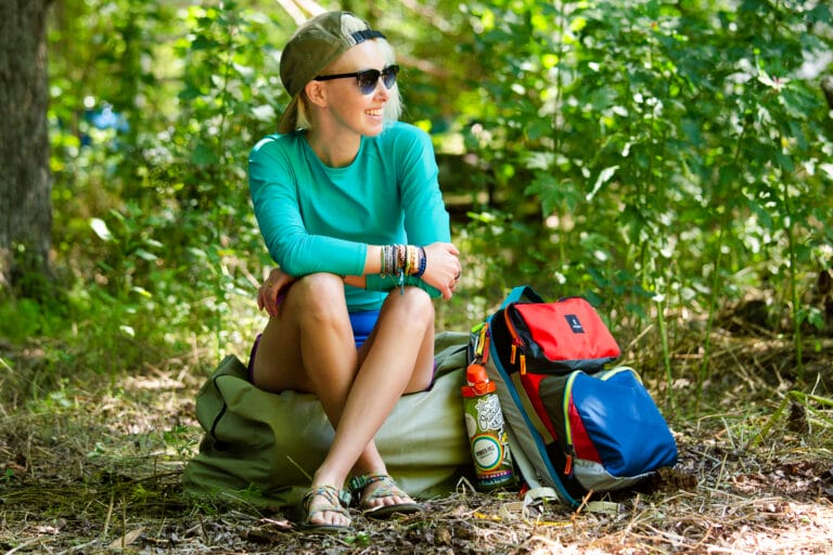 Woman sitting outdoors with a backpack