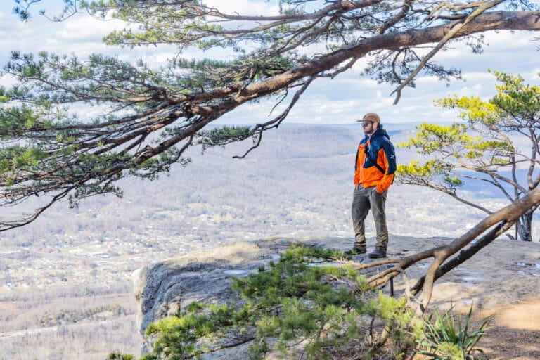A man stands at the lookout point on Sunset Rock.